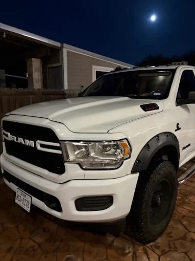 Freshly detailed white Ram truck parked at night under a full moon, Brownsville TX